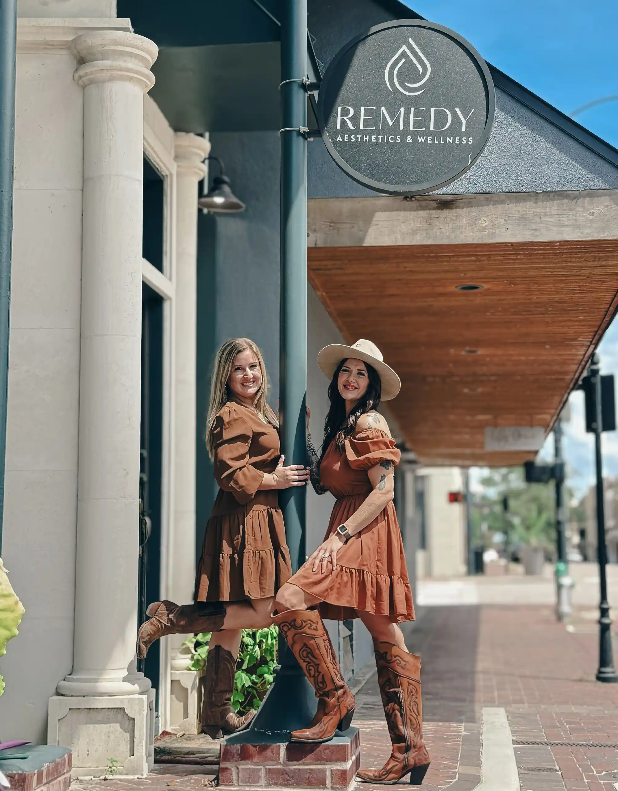 Staff posing under the Remedy Victoria, Texas clinic exterior sign
